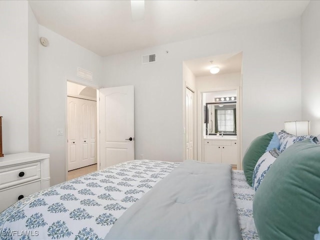 bedroom with a sink, connected bathroom, visible vents, and a ceiling fan