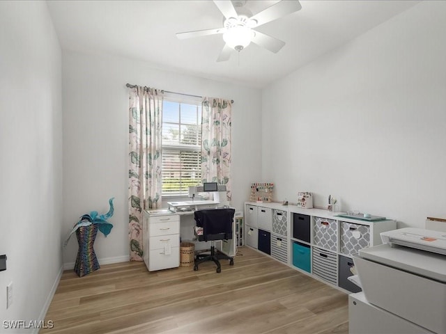 office area with a ceiling fan, light wood-style flooring, and baseboards