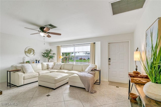 living area featuring a ceiling fan, visible vents, baseboards, and light tile patterned floors