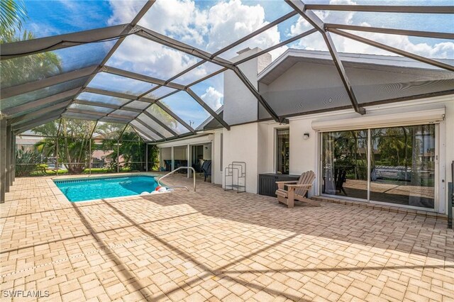 pool with a lanai and a patio area