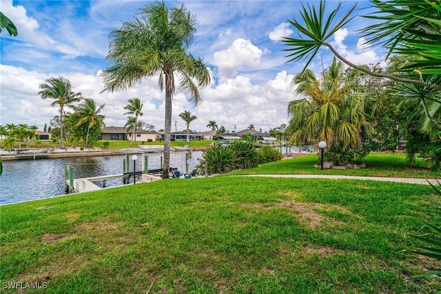 view of dock with a water view and a lawn