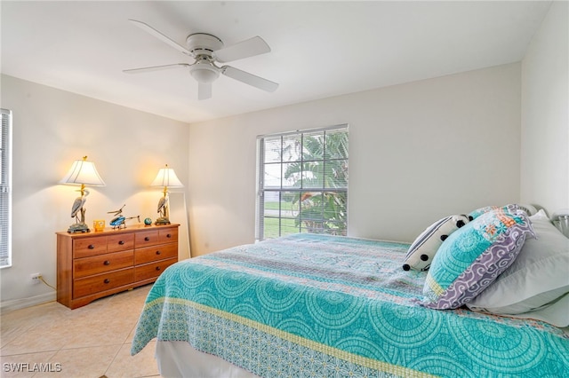 tiled bedroom featuring ceiling fan and baseboards