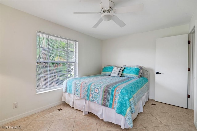 bedroom featuring ceiling fan, light tile patterned flooring, and baseboards