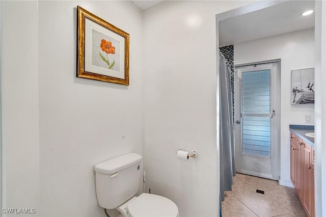 bathroom with toilet, tile patterned flooring, and vanity