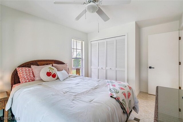 bedroom featuring a ceiling fan, a closet, and light tile patterned floors