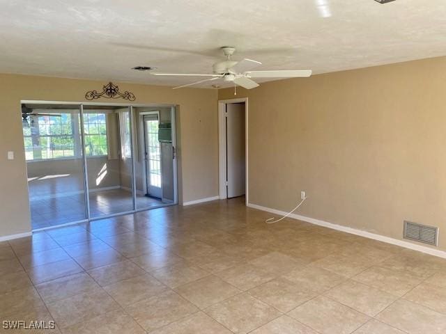 unfurnished room featuring a ceiling fan, visible vents, and baseboards