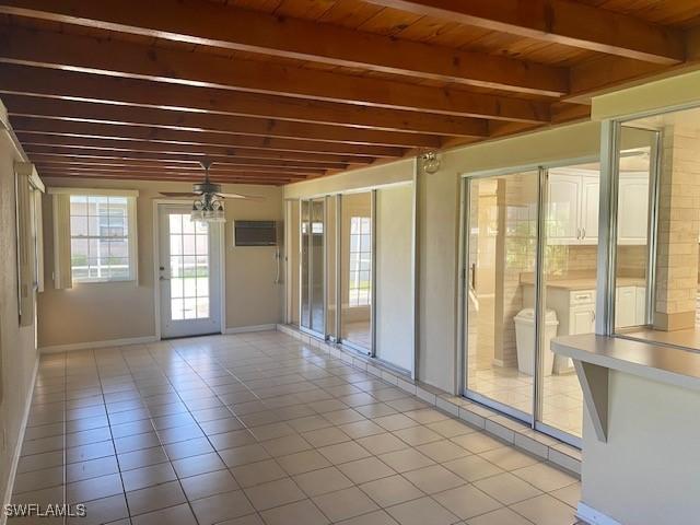 interior space featuring light tile patterned floors, baseboards, wood ceiling, ceiling fan, and beam ceiling