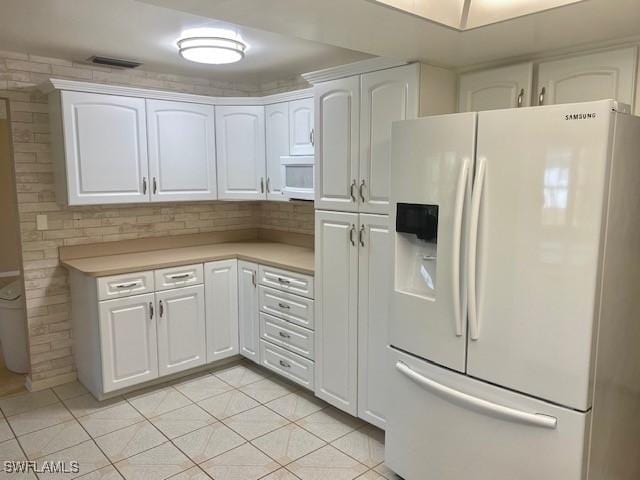 kitchen featuring white appliances and white cabinetry