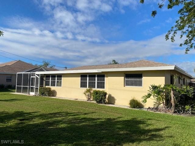 back of house featuring a lawn and stucco siding