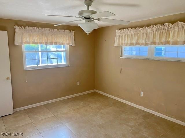 empty room featuring ceiling fan and baseboards