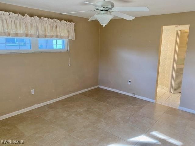 unfurnished room featuring light tile patterned flooring, ceiling fan, and baseboards