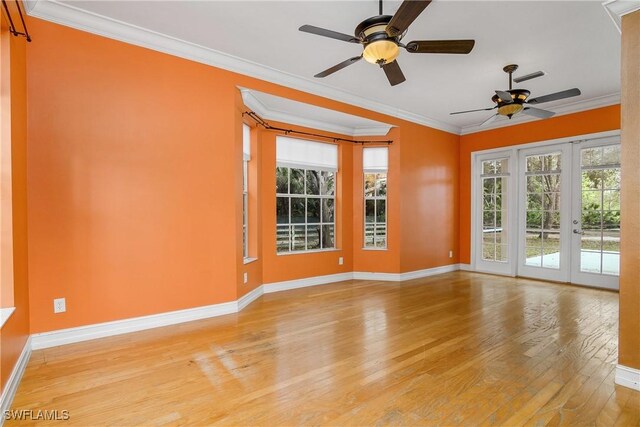 spare room featuring wood finished floors, visible vents, baseboards, french doors, and ornamental molding