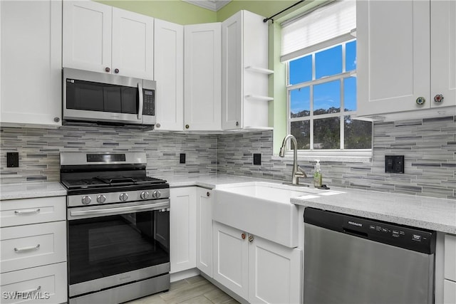 kitchen with tasteful backsplash, white cabinetry, and stainless steel appliances