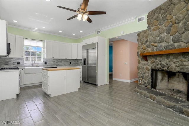 kitchen featuring visible vents, decorative backsplash, stainless steel appliances, light countertops, and a sink