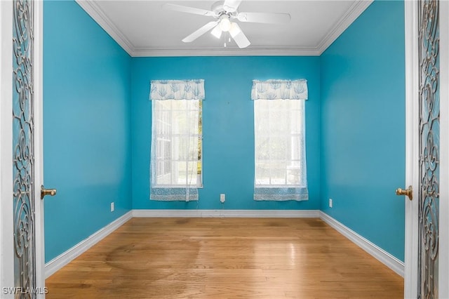 empty room with ceiling fan, crown molding, and wood finished floors