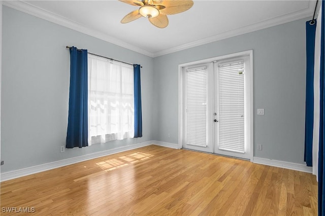 empty room featuring ornamental molding, light wood-style flooring, baseboards, and a ceiling fan