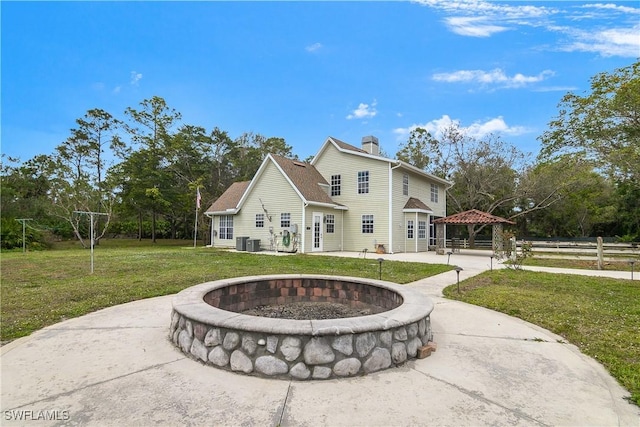 rear view of house with a yard, a chimney, a gazebo, a patio area, and driveway