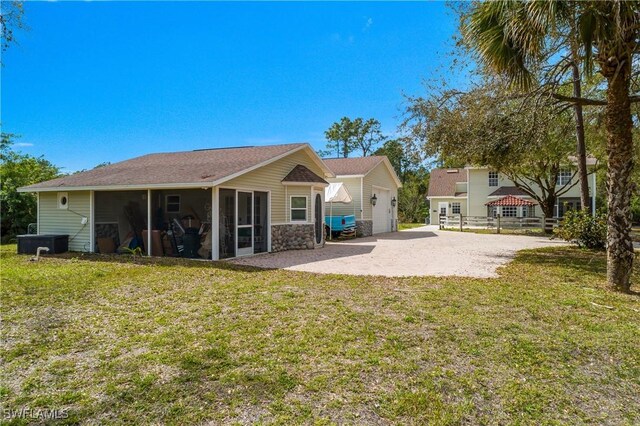 back of property featuring a sunroom, a lawn, and a patio