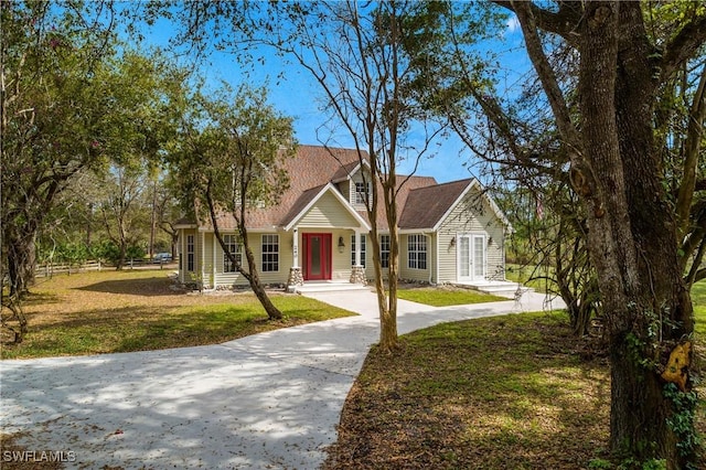 view of front facade featuring fence, a front lawn, and concrete driveway