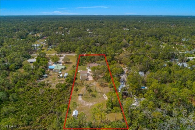 birds eye view of property featuring a forest view