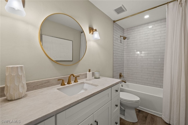 full bathroom with toilet, wood finished floors, vanity, visible vents, and shower / bath combo with shower curtain