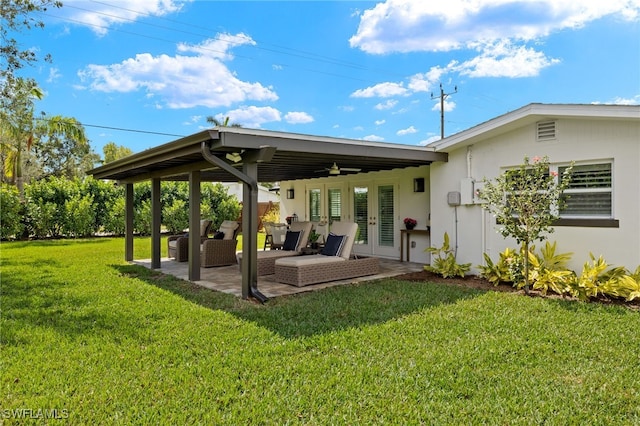 back of property with a ceiling fan, a patio, french doors, an outdoor hangout area, and a yard