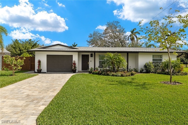 single story home with a garage, fence, decorative driveway, stucco siding, and a front yard