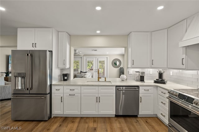 kitchen with stainless steel appliances, tasteful backsplash, and white cabinets