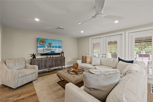 living room with light wood finished floors, french doors, a ceiling fan, and a healthy amount of sunlight