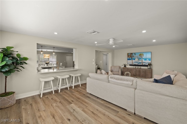 living area featuring light wood-style floors, recessed lighting, visible vents, and baseboards