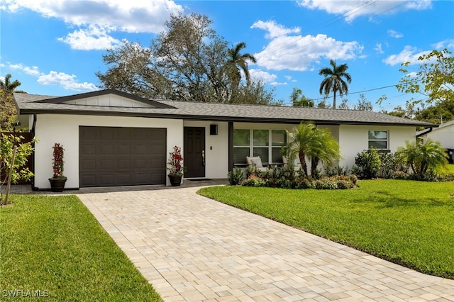 ranch-style house with an attached garage, decorative driveway, a front yard, and stucco siding