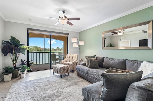 living area with light tile patterned floors, visible vents, a ceiling fan, and ornamental molding