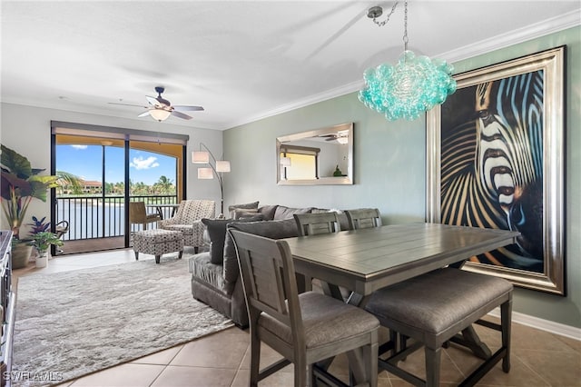 dining area with ceiling fan with notable chandelier, ornamental molding, baseboards, and tile patterned floors