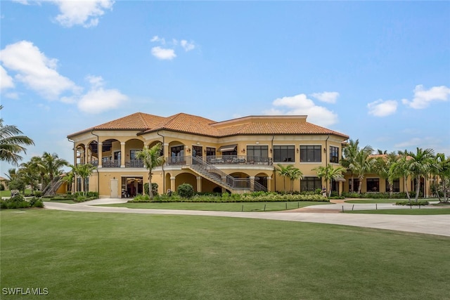 view of front facade with stucco siding, a front lawn, and a tiled roof