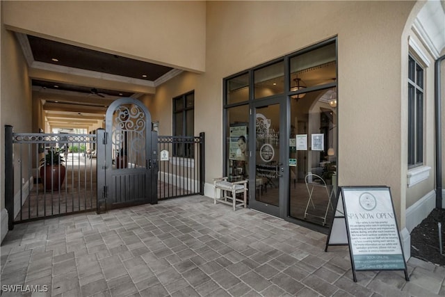 doorway to property with a gate and stucco siding