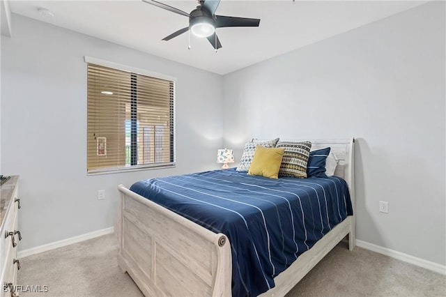 bedroom with a ceiling fan, light carpet, and baseboards