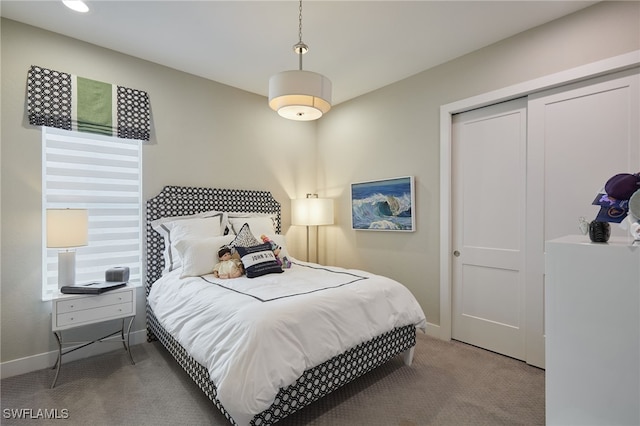 bedroom with a closet, carpet, and baseboards