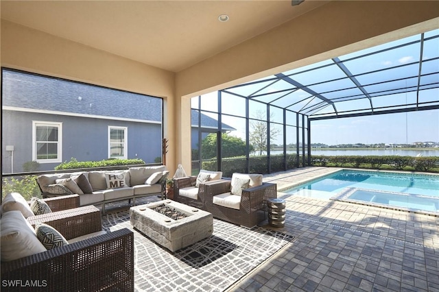 view of pool with an outdoor living space with a fire pit, a patio, a pool with connected hot tub, a water view, and glass enclosure