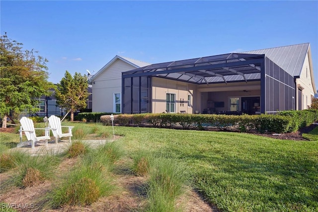 rear view of property featuring a yard and a lanai