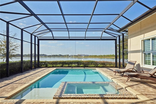 view of pool featuring a water view, glass enclosure, a pool with connected hot tub, and a patio