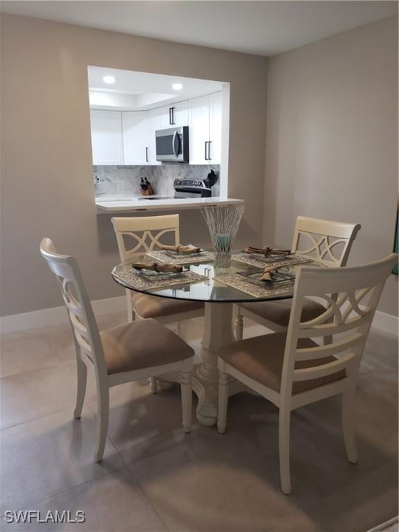 dining space featuring light tile patterned floors and baseboards