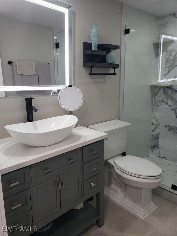 bathroom with toilet, a stall shower, and vanity