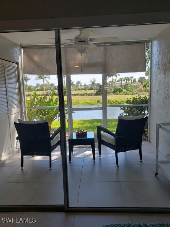 sunroom with a water view and ceiling fan