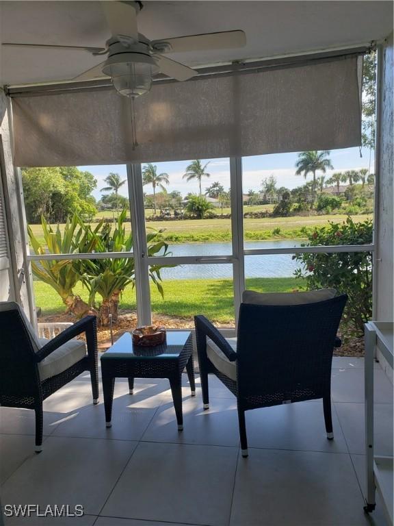 sunroom / solarium with ceiling fan, a water view, and a healthy amount of sunlight