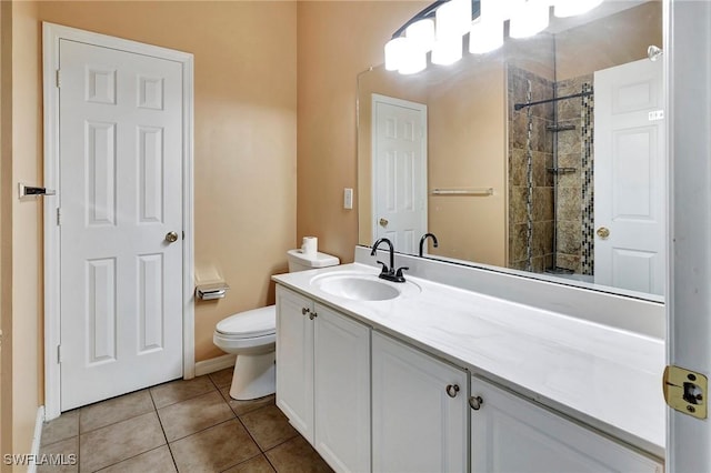 full bath featuring toilet, vanity, tiled shower, and tile patterned floors