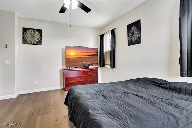 bedroom with wood finished floors, a ceiling fan, and baseboards