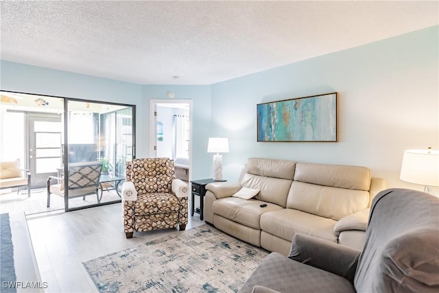 living area with a textured ceiling and wood finished floors