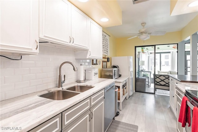 kitchen featuring white cabinetry, a sink, backsplash, and dishwasher