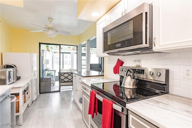 kitchen featuring ceiling fan, appliances with stainless steel finishes, white cabinetry, and decorative backsplash