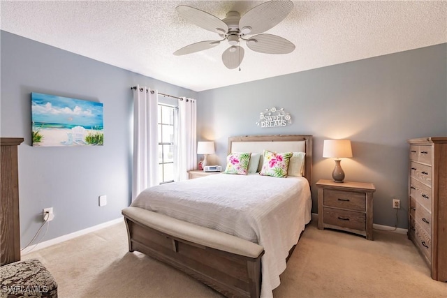 bedroom with light colored carpet, ceiling fan, a textured ceiling, and baseboards